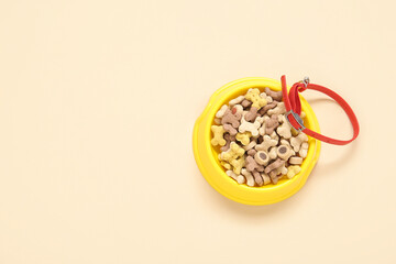 Bowl of dry pet food and collar on color background