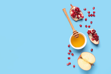 Bowl of honey with pomegranate and apple for Rosh Hashanah celebration (Jewish New Year) on grey background