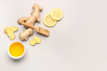 Fresh ginger root, slices of lemon and wooden scoop with dried powder on grey background