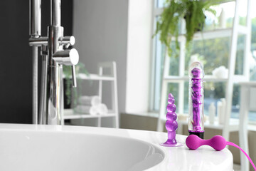 Sex toys on bathtub in room, closeup