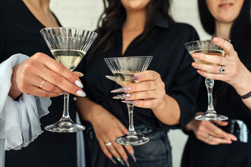 Elegant gathering of friends celebrating special moments with cocktails in stylish attire at a chic venue during the evening