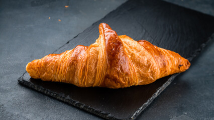 Breakfast fresh croissant on black background.