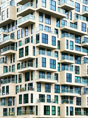 Modern Geometric Yellow Architecture Building With Balconies, Logias And Outdor Living Spaces With Lots Of Blue Windows, Huge Constructions Skyscrapers With Windows for Vertical Wallpaper