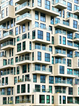 Modern Geometric Yellow Architecture Building With Balconies, Logias And Outdor Living Spaces With Lots Of Blue Windows, Huge Constructions Skyscrapers With Windows for Vertical Wallpaper
