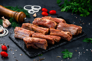 Portion raw pork ribs for grilling with spices and salt.