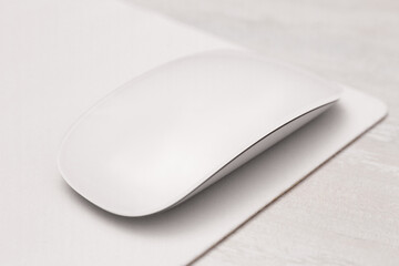 Computer mouse with mousepad on light wooden table, closeup