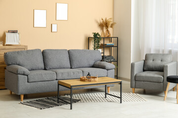 Interior of stylish living room with black sofa, armchair, rugs and coffee table