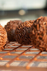 Close-up of Brazilian brigadeiros, a popular chocolate dessert, on a wire rack.