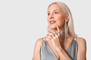 Naklejka premium Fashionable mature woman in beautiful jewelry on white background