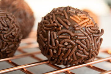 Close up of chocolate brigadeiros covered in chocolate sprinkles.