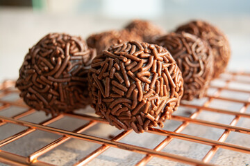 Close-up of chocolate brigadeiros on a wire rack.
