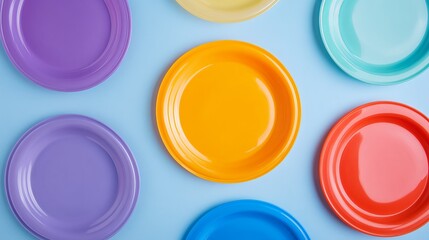 Flat lay image of colorful plastic frisbees on a light blue background, leaving ample space for text or branding. 
