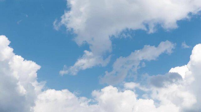 Timelapse video of white clouds moving across a vibrant blue sky in summer. The dynamic play of light and color showcases the beauty of nature in ever-changing, cloudy weather
