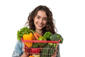 A woman carrying a basket filled with fresh vegetables