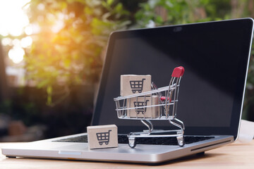 Shopping online. cardboard box with a shopping cart logo in a trolley on laptop keyboard. Shopping service on The online web. offers home delivery