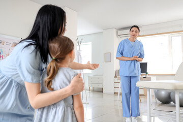 Fototapeta premium Mother and female osteopath working with little patient in clinic