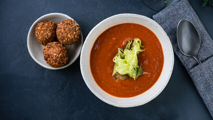 Tomato soup with fried cheese balls and herbs.