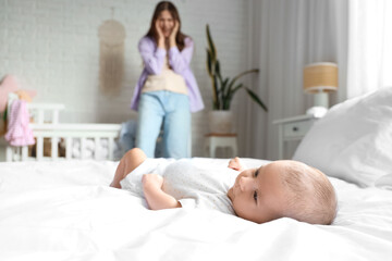 Baby and young mother suffering from postnatal depression at home