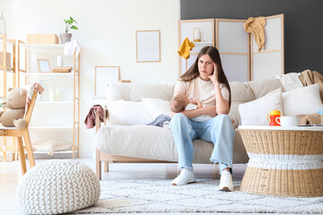 Stressed young mother suffering from postnatal depression at home