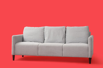Grey sofa on red background