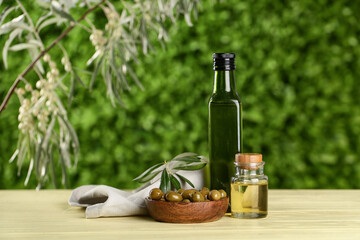 Bottles of fresh olive oil on wooden table outdoors