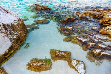 A rocky shoreline with a body of water in the background