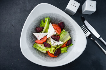 Lunch green salad with tomatoes, lettuce, feta cheese and beets.