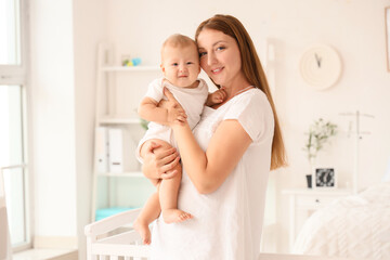 Young mother with her newborn baby in maternity hospital