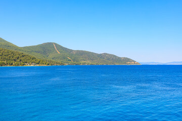 Obraz premium A beautiful blue ocean with a mountain in the background