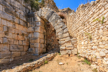 Obraz premium A stone archway with a small opening in the middle. Ruins of the ancient city of Philippi, Greece