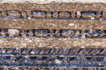 A stone wall with a pattern of lines and dots. Ruins of the ancient city of Philippi, Greece
