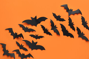 Black paper bats for Halloween party on orange background