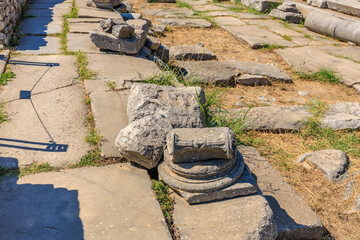 A stone slab with a hole in it is sitting on stone slab. Ruins of the ancient city of Philippi,...