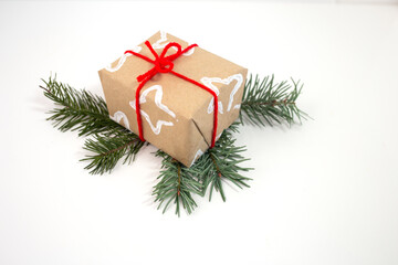 Creative gift wrap brown paper with white stars from folded toilet paper roll, bright red ribbon. Festive and unique design using common household items for an inventive touch