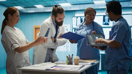 Medical professionals review x ray results and discuss patient care strategies during a meeting. Team of licensed healthcare experts working to provide accurate diagnosis in a clinic. Camera B.