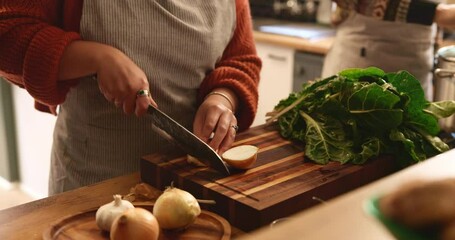 Hands, couple and knife for cooking in kitchen with meal prep, healthy dinner and cutting ingredients. People, food and fresh produce with onions, spinach and vegan recipe for nutrition and wellness