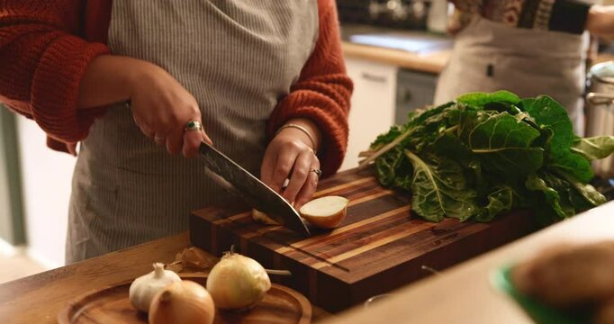 Hands, couple and knife for cooking in kitchen with meal prep, healthy dinner and cutting ingredients. People, food and fresh produce with onions, spinach and vegan recipe for nutrition and wellness