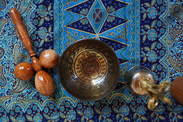 Tibetan singing bowl in sound therapy on black silk background, alternative medicine