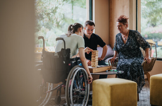 A group of people enjoying a game in a warm room, highlighting inclusivity and connection. The atmosphere is relaxed and inviting, showcasing friendship and laughter.