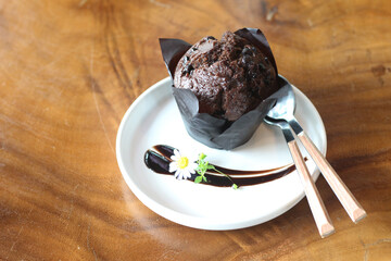 Muffins on plate placed on a wooden table.