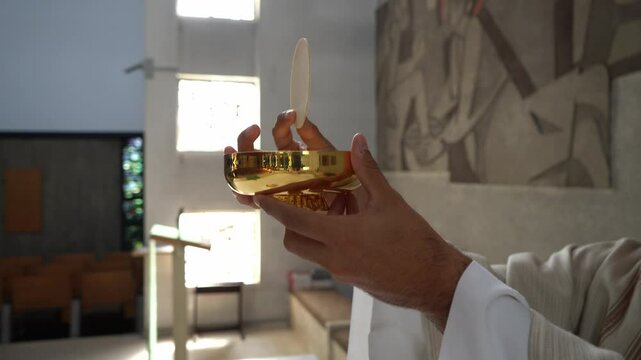 Priest in a Catholic church consecrating the host during mass.
