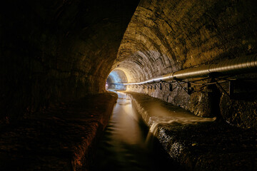 Underground vaulted urban sewer tunnel with dirty sewage