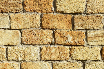 Old yellow wall made of natural stone blocks. Shell stone wall of an ancient building