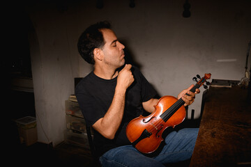 Luthier in his workshop making a violin