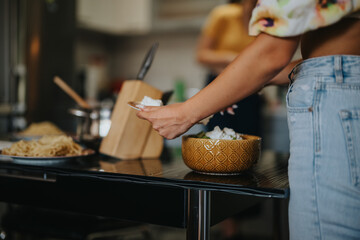 A close-up view of a woman serving food in a modern kitchen, emphasizing casual dining and homemade meals in a comfortable setting.