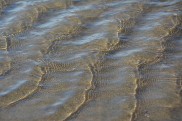 Clear water on a calm beach, with small waves on vacation