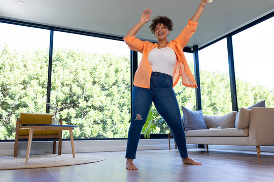 Dancing energetically, plus size woman enjoying routine at home