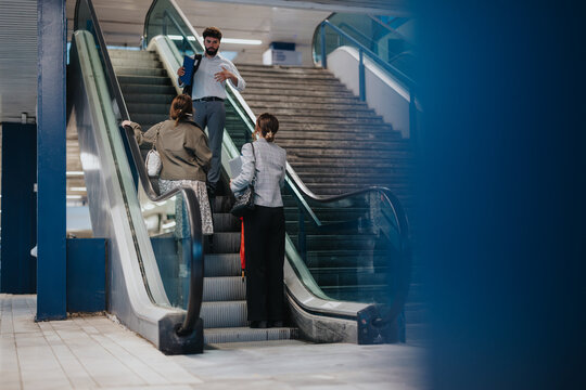 Group of business people having a conversation while riding an escalator in a contemporary office building, focusing on professional interaction and workplace atmosphere.