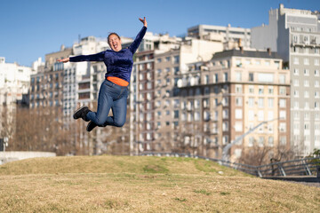 Woman celebrating, jumping for joy in a park