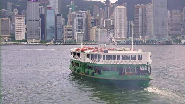 Hong Kong ferry boat in Victoria Harbor, passenger ship from Kowloon island to Hong Kong. Work commute in modern Asian city and global financial centre in China. 